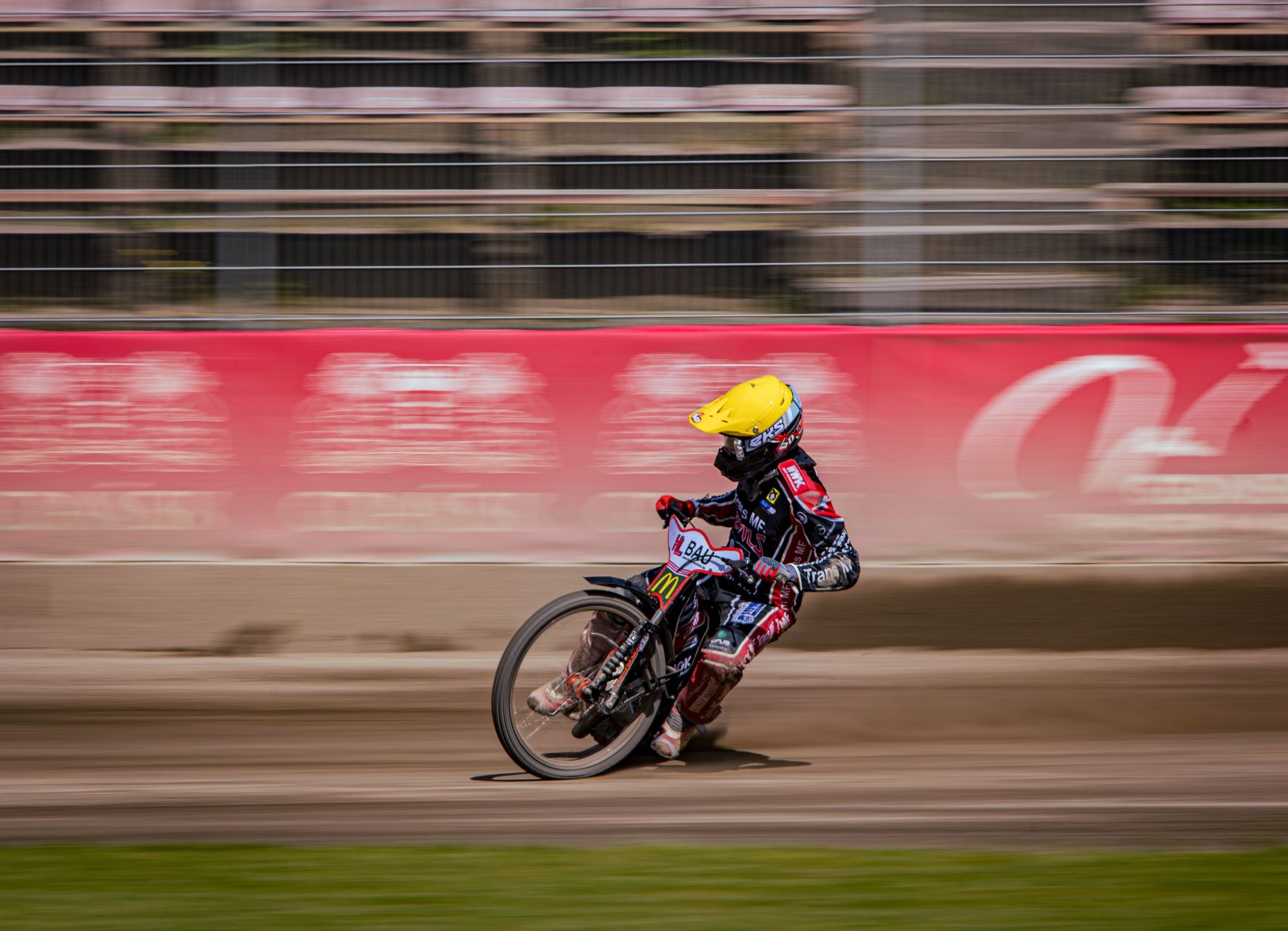 Speedway-Fahrer driftet quer durch die Kurve auf der Aschenbahn