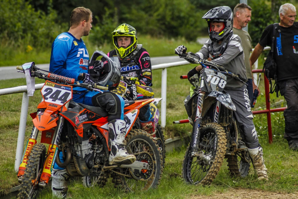 Motocross-Fahrer und Betreuer vor einem Trainingsturn, Symbolbild