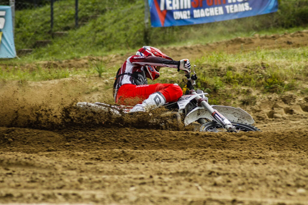 Motocross-Fahrer legt sich mit Sandfontäne in die Kurve, Symbolbild für das Training beim MC Wolgast