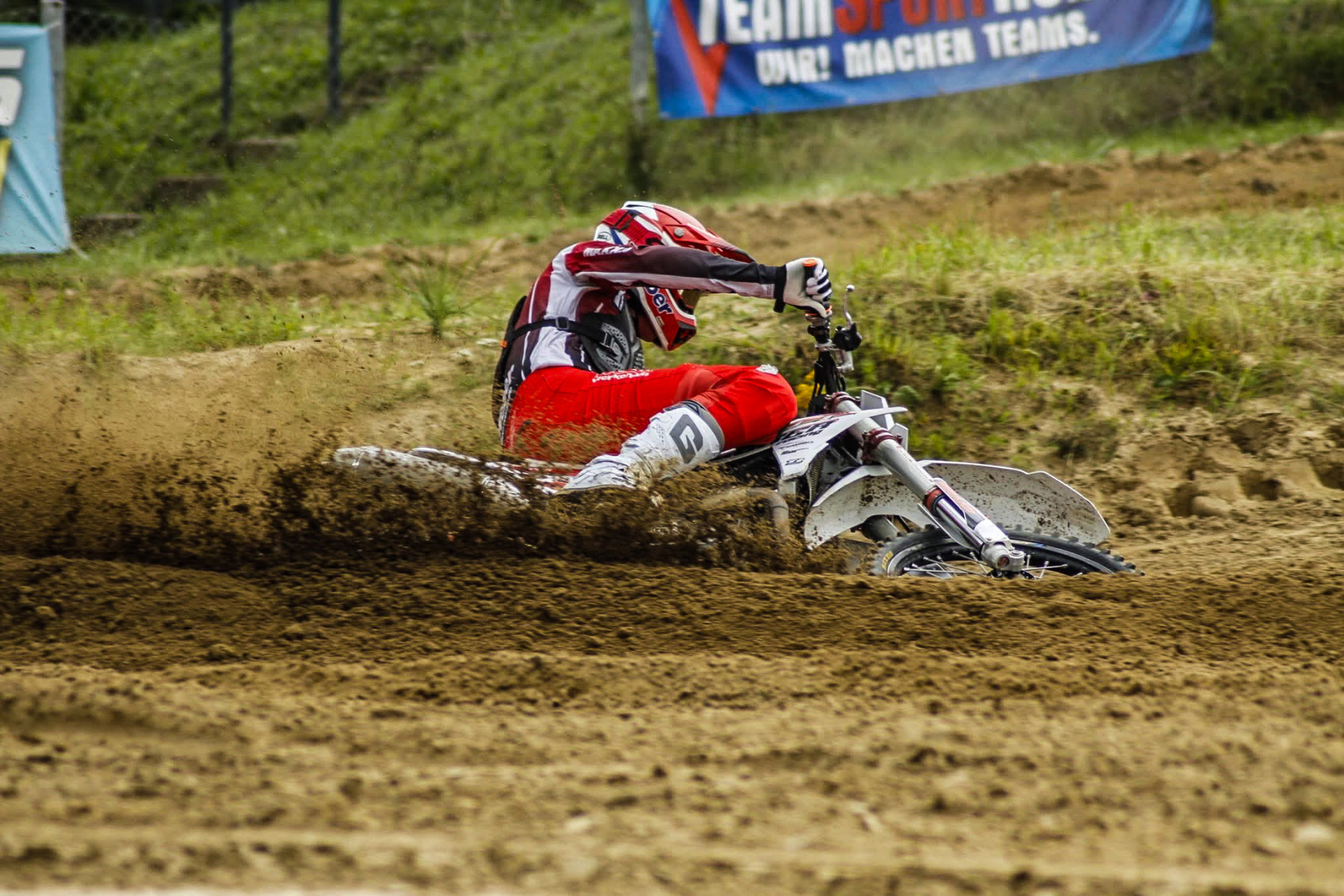 Motocross-Fahrer legt sich mit Sandfontäne in die Kurve, Symbolbild für das Training beim MC Wolgast