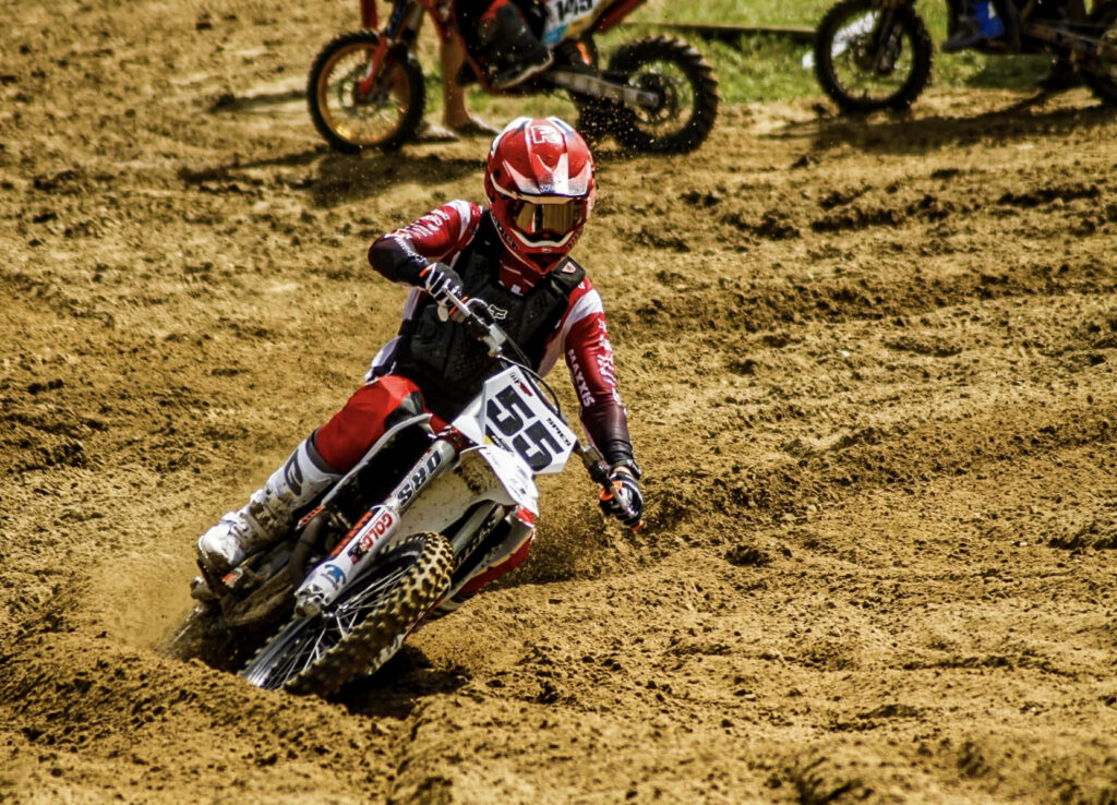 Junger Motocross-Fahrer legt sich in eine sandige Kurve, Symbolbild für das Training in Wilhelmsburg