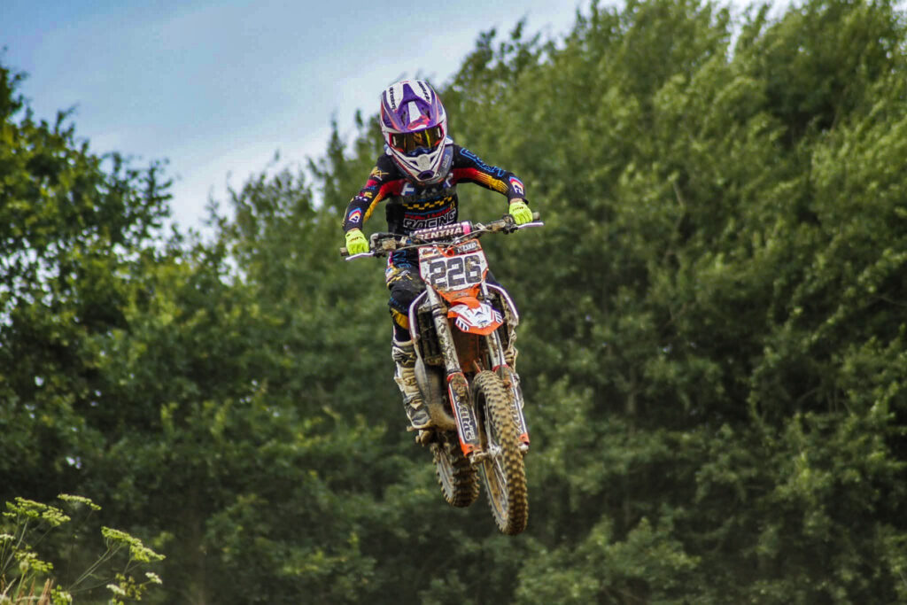 Junger Motocross-Fahrer mit Startnummer 226 im Sprung vor Bäumen, Symbolbild für das Training in Prisannewitz