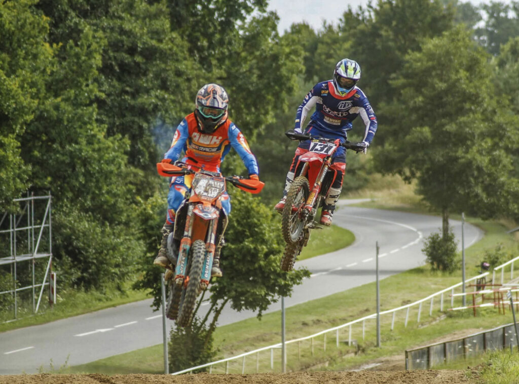 Zwei Motocross-Fahrer hintereinander im Sprung vor Bäumen, Symbolbild für das Training in Wilhelmsburg