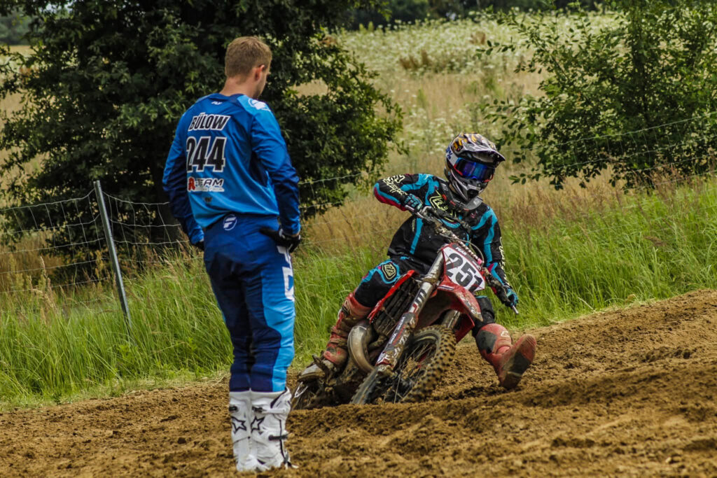 Trainer beobachtet einen jungen Motocross-Fahrer beim Training, Symbolbild